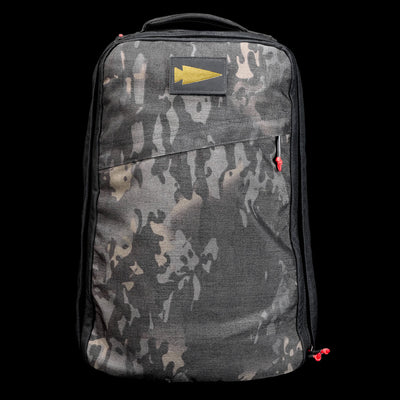 The GR1 Shooter 26L - Built by Scars is a camo-patterned backpack crafted from rugged CORDURA®, with a yellow arrow patch and red zipper pulls, shown on a black background.