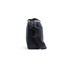 Side view of the Shoulder Bag - Waxed Canvas in dark gray, featuring a black strap for asymmetrical carry, displayed against a white background.