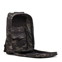 A GR1 USA Slick - Ballistic Nylon Cordura backpack stands upright with its front fully unzipped, showing interior pockets and a bombproof laptop compartment.
