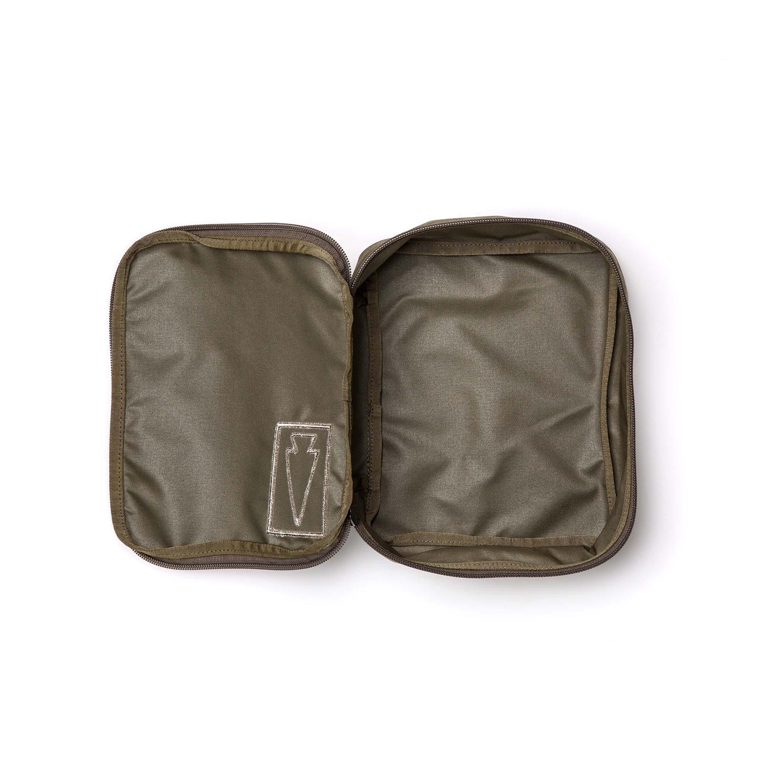 The Shadow Pocket is an open, empty olive green Cordura pouch with a stitched lightning bolt symbol on the left—perfect for rucksack organization or as a compact gear organizer.