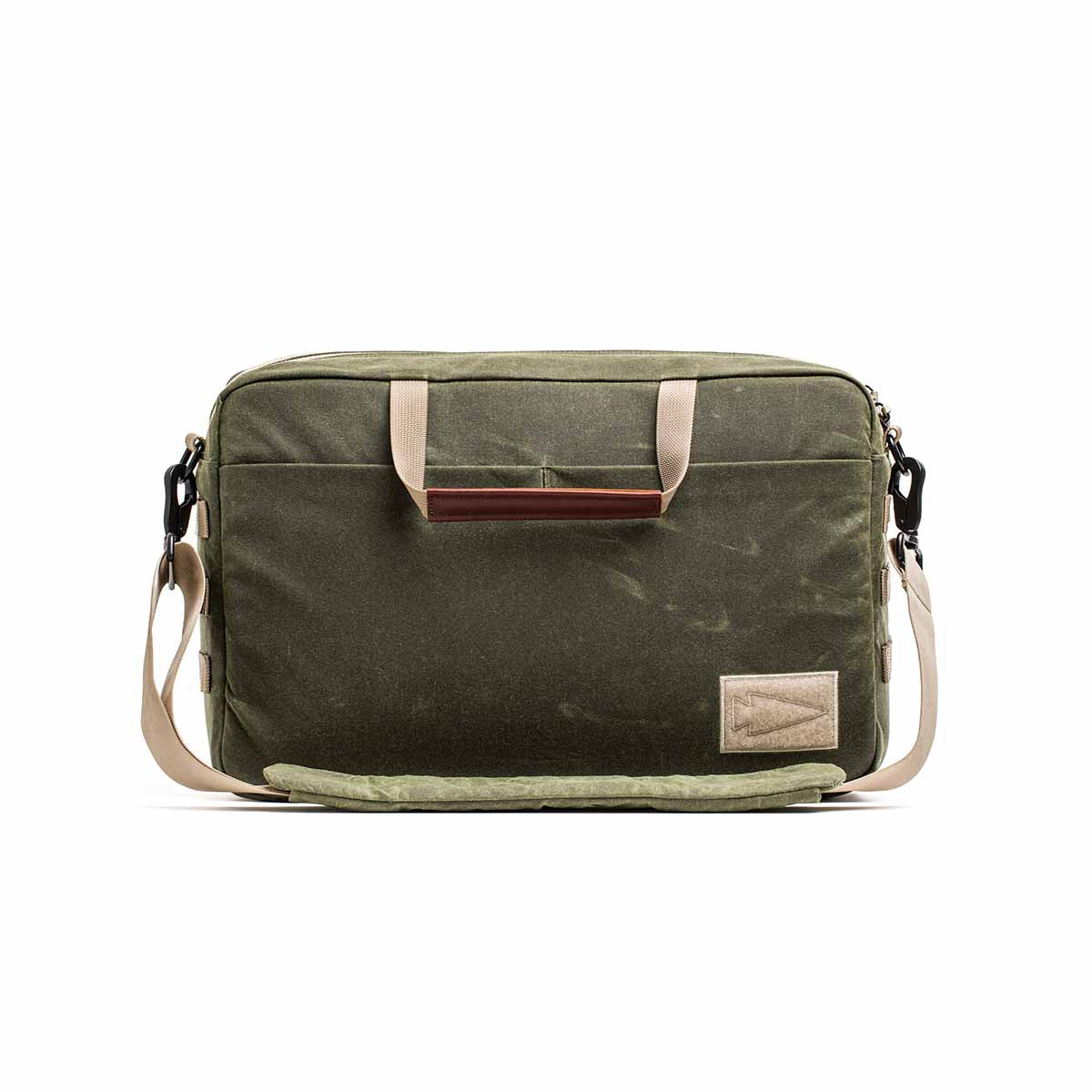 The Shoulder Bag - Waxed Canvas features olive green canvas, beige straps, a front pocket, and a brown-accented handle. Its Martexin Wax finish ensures durability and style—ideal for versatile asymmetrical carries.