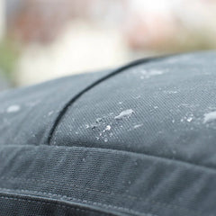 Close-up of water droplets on dark grey fabric, highlighting the GR1 USA Slick - Ballistic Nylon Cordura backpack’s Special Forces-grade quality and outdoor durability.