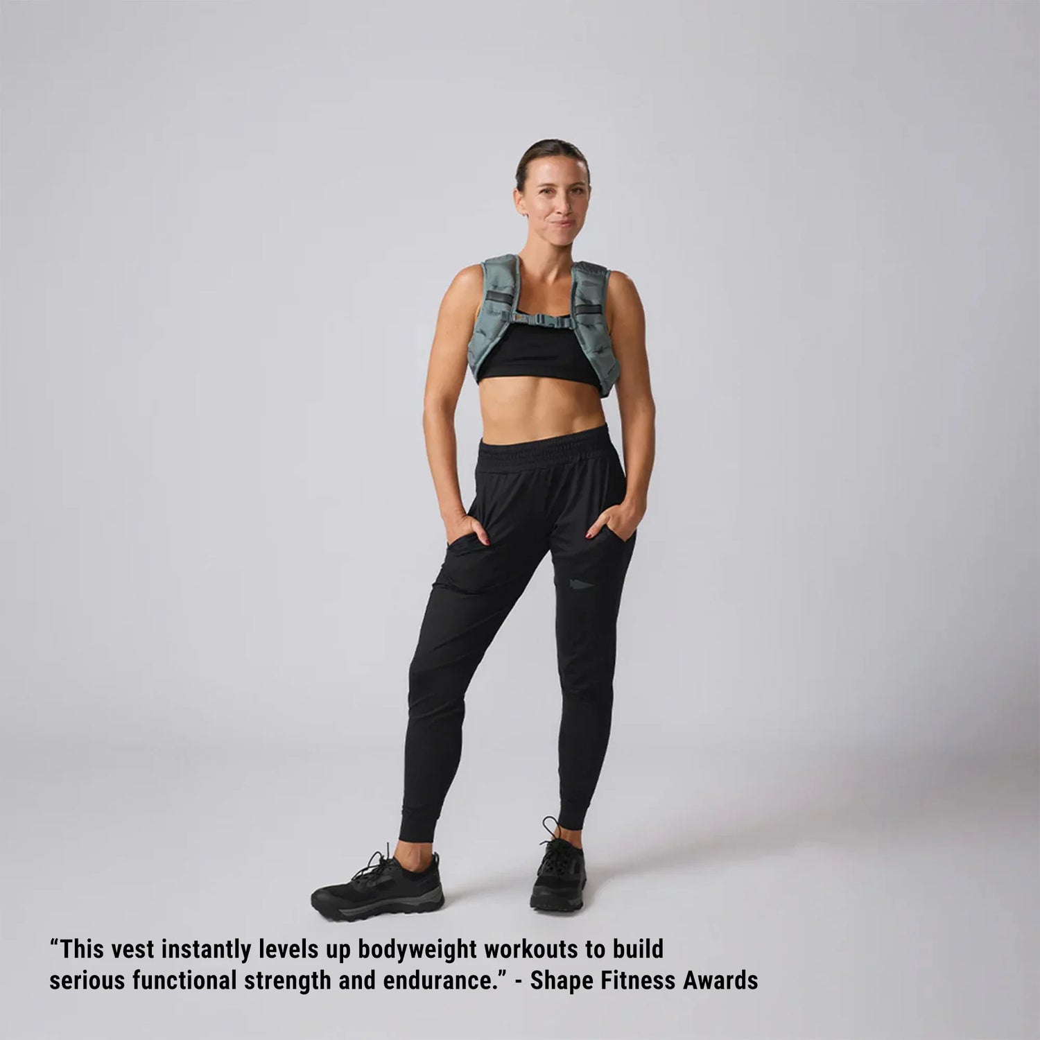 Woman wearing GORUCK ruck vest in Storm color, black workout outfit, fitness award quote
