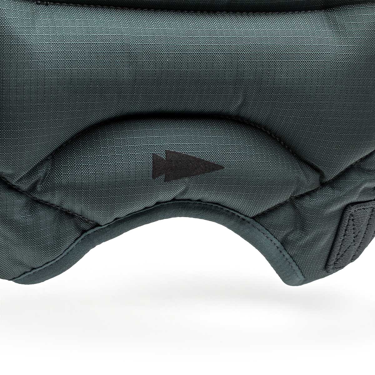 Close-up of dark green padded fabric from the Spy Ruck | Women's Weighted Vest, featuring a black arrow symbol.