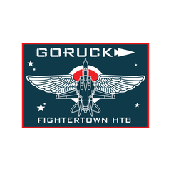 GORUCK Fightertown HTB patch featuring a stylized fighter jet with wings, a circular target emblem, and stars on a dark background, celebrating the legacy of Fightertown USA.