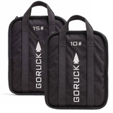 The Sand Ruck Plate Bundle includes two black bags marked 15 and 10, each with handles and arrow designs—essential rucking gear, ideal for use with your favorite ruck plate or sand ruck plate.