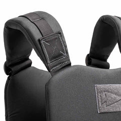 Close-up of padded black backpack shoulder straps attached to a textured fabric back panel, offering durability similar to the Training Weight Vest 2.0.