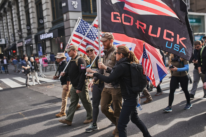A group of people walking in a street holding flags.