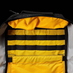 Open GORUCK XPAC 21L rucksack showing bright yellow interior with black webbing organizer