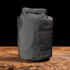 GORUCK Armor Grey rugged rucking sandbag on wooden table, black background