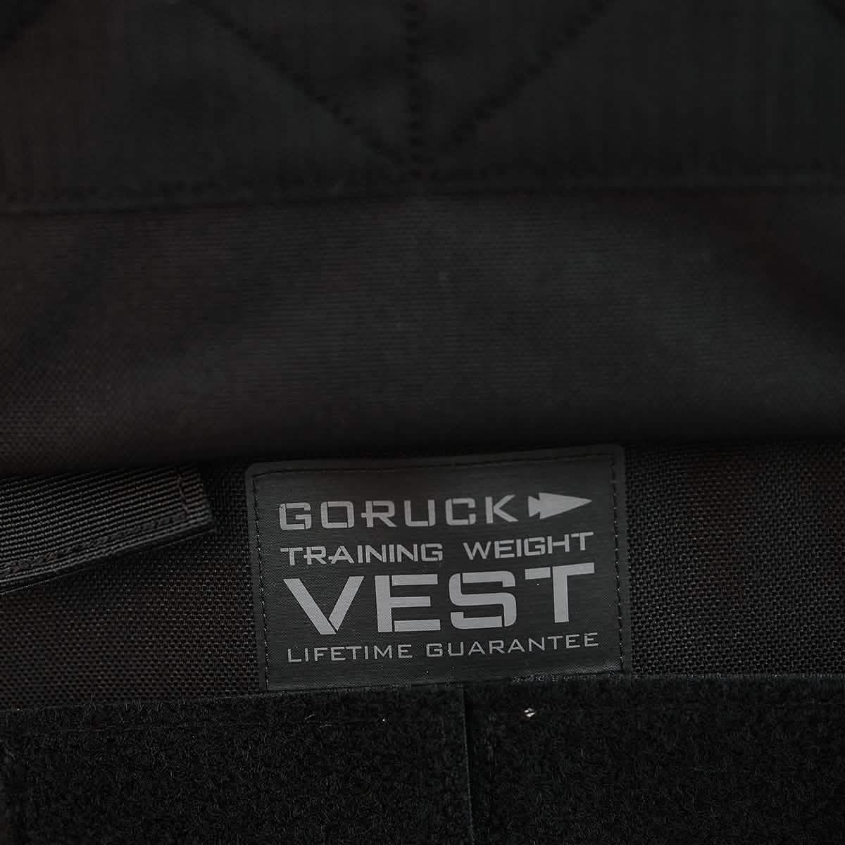 A close-up of a black fabric tag on a garment features the text 