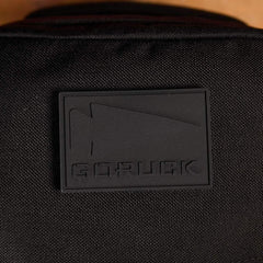 Close-up of black GORUCK logo patch on durable textured rucking gear fabric