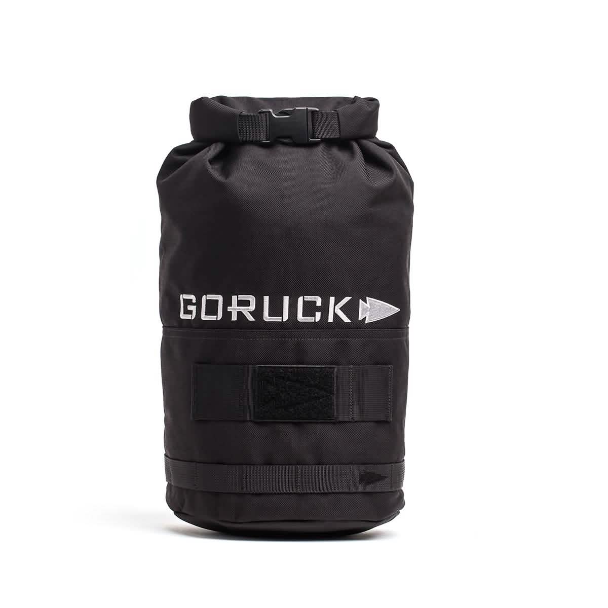 Introducing the Brick Bag (5-50 LBS) by GORUCK: A black rucksack featuring the GORUCK and arrow logo in white. This bag is designed with a roll-top closure, Velcro straps, and a durable exterior. Inspired by military gear, it functions as versatile training equipment or a dependable stuff sack for your adventures.