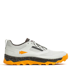 Introducing the GORUCK Mackall in Glacier and Ignition Orange: a low-top athletic shoe tailored for Special Forces training. It showcases a white and gray color scheme with striking orange accents, including a textured orange sole. The distinctive arrow logo on the side and speckled midsole detailing offer enhanced durability, making it ideal for rucking enthusiasts.