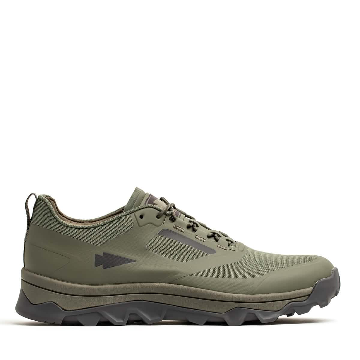 A GORUCK Mackall - Earth + Forged Iron trail shoe with a rugged triple compound outsole and streamlined design is displayed against a white background. Equipped with laces and a subtle arrow logo on the side, it seamlessly combines style and functionality, making it ideal for outdoor activities like rucking.
