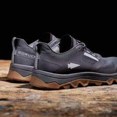 GORUCK forged iron rugged black and brown trail running shoes on wooden floor