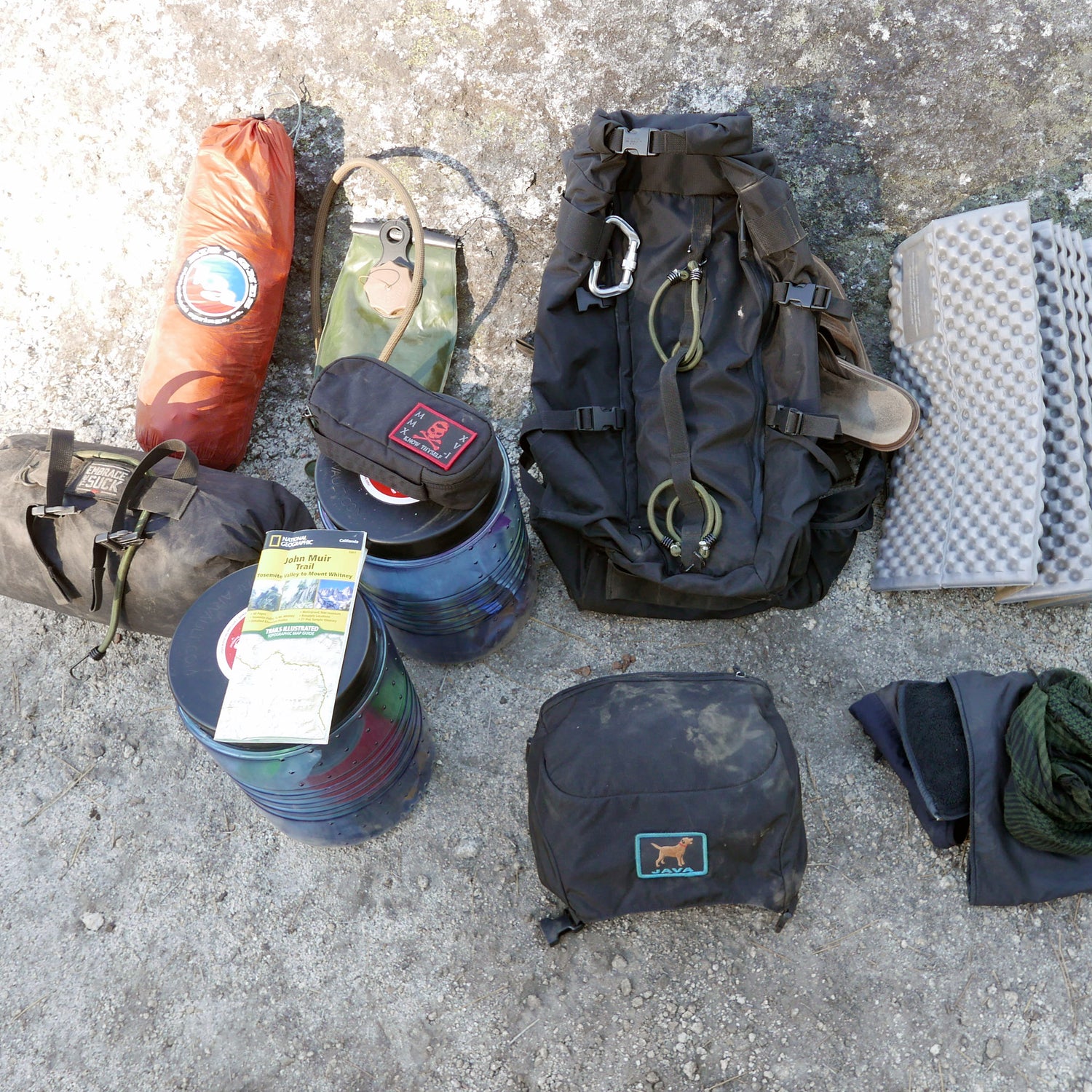 The GR MONSTER Bundle - PREORDER, featuring camping gear such as a GORUCK rucksack, tent, sleeping pad, map, bowls, gloves, and tarp, is arranged on the ground.