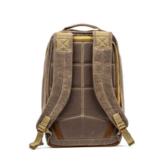 The GR1 USA - Heritage by GORUCK is crafted with waxed duck canvas and enhanced with a Martexin Wax finish, highlighting its robust construction from the back. It includes padded shoulder straps, a top handle, leather accents, and visible stitching that emphasizes its timeless durability.