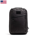 A GR2 USA x Carryology - Ultra Black backpack with a front zipper pocket, made from durable UHMWPE fabric, shown on a white background with a small US flag in the corner.