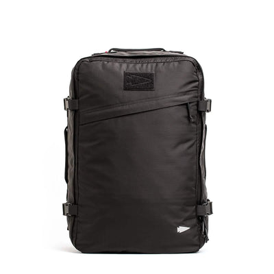 Introducing the GR3 - Ripstop ROBIC® by GORUCK: a sleek black carry-on rucksack with a rectangular design, constructed from robust Robic nylon. It includes multiple zippers, side buckle straps, and a small triangular logo prominently displayed on the top front—perfect for travel or outdoor adventures.