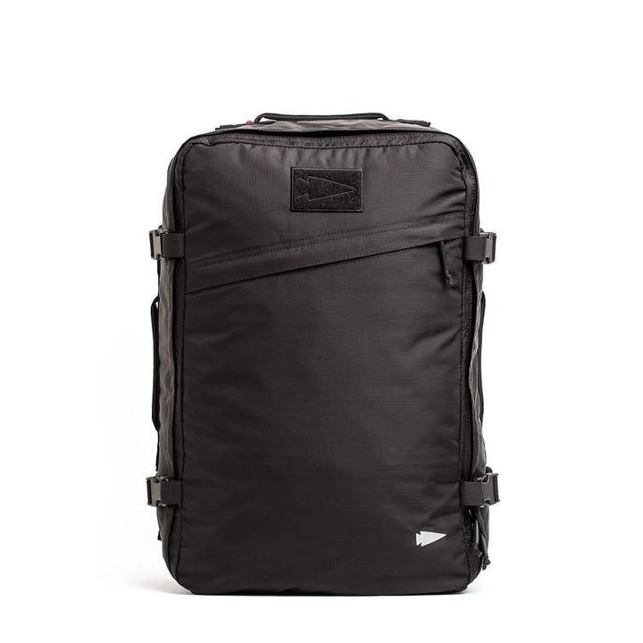 Introducing the GR3 - Ripstop ROBIC® by GORUCK: a sleek black carry-on rucksack with a rectangular design, constructed from robust Robic nylon. It includes multiple zippers, side buckle straps, and a small triangular logo prominently displayed on the top front—perfect for travel or outdoor adventures.