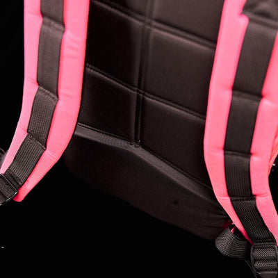 Close-up of a GORUCK Bullet Ruck Laptop - 14L showcasing vivid pink padded straps and a black padded back panel, featuring a bombproof laptop compartment, set against a dark background.
