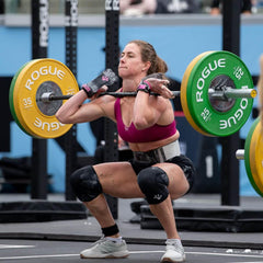 Female athlete lifting barbell during gym competition, showcasing strength and GORUCK gear