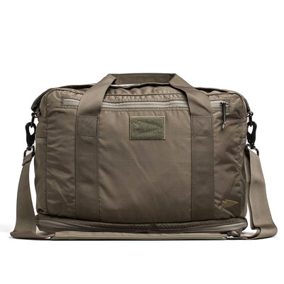 The Kit Bag with Shoe Compartment by GORUCK, constructed from Ripstop ROBIC® material, features a khaki green rectangular design reminiscent of a Special Forces Flight Bag. It includes multiple straps and zippers, along with a subtle logo patch on the front. For added convenience, it comes with a shoulder strap. Its rugged and utilitarian style makes it perfect for travel or daily use.