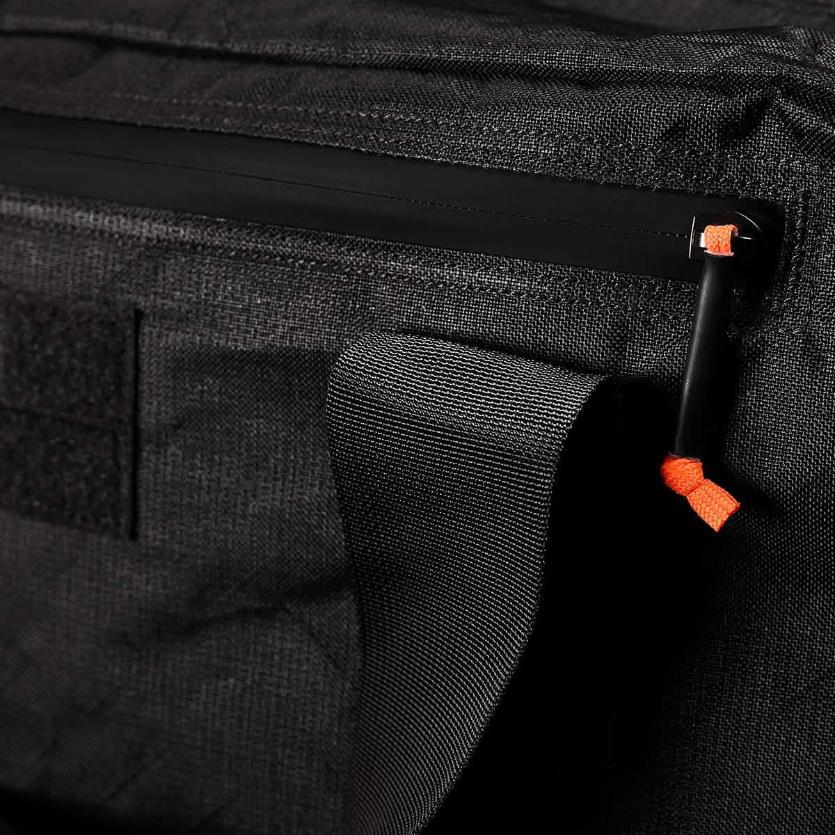 Close-up of the Kit Bag x Carryology - Ultra Blaze, featuring a shoe compartment, black zipper and pull tab with orange accent. Made from durable UHMWPE fabric.