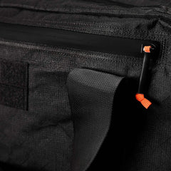 Close-up of the Kit Bag x Carryology - Ultra Blaze, featuring a shoe compartment, black zipper and pull tab with orange accent. Made from durable UHMWPE fabric.