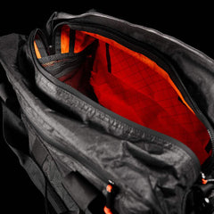 The Kit Bag x Carryology - Ultra Blaze features an open zipper showing a vibrant orange interior, mesh pocket, and shoe compartment—all crafted from durable UHMWPE fabric.