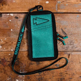 GORUCK teal lanyard wallet with arrowhead logo on rustic wood background