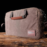 GORUCK rugged brown canvas messenger bag on wooden table
