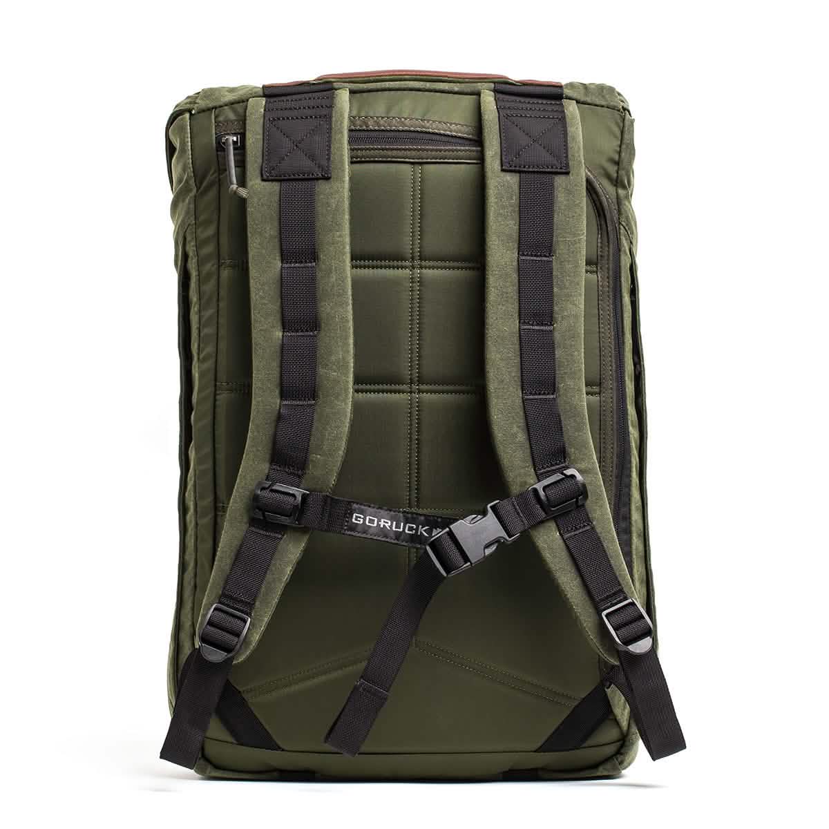 The M23 - Waxed Canvas by GORUCK is a contemporary field pack in green, equipped with black padded shoulder straps and a sternum strap for added stability. Its quilted back panel ensures comfort, while showcasing the iconic GORUCK standard, perfectly merging functionality with style.