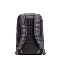 The GR1 rucksack in black and gray is shown from the back, featuring padded shoulder straps and a cushioned back panel, designed for exceptional durability to meet Special Forces standards.