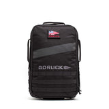 The Rucker 5.0 is a black GORUCK rucksack featuring an American flag patch, front handles, MOLLE webbing on the lower front, and built-in lumbar support for comfortable rucking.