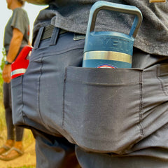 Close-up of a blue Yeti water bottle in the back pocket of Men’s Simple Shorts - Lightweight ToughDry®, with another person blurred in the background.
