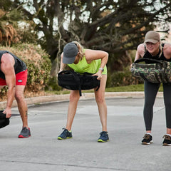 Women training outdoors with GORUCK rucksacks during a fitness rucking workout