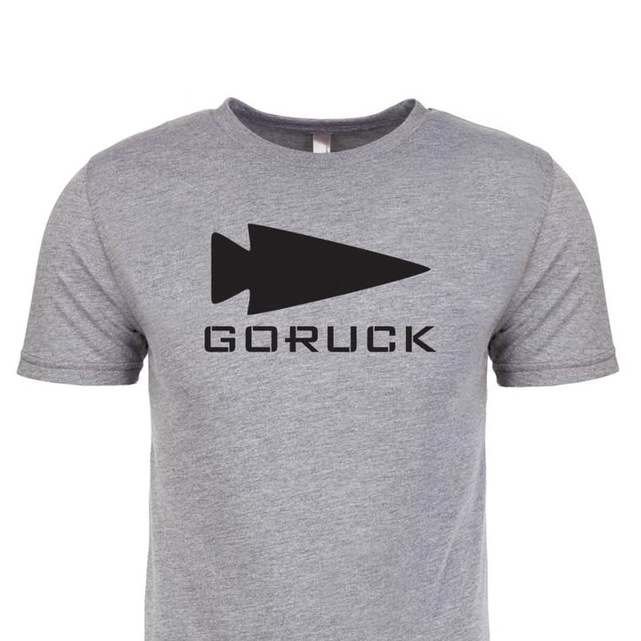 Introducing the Three Rules Tee - Tri-Blend: a gray t-shirt made from premium tri-blend fabric, showcasing a prominent black arrowhead logo above the word GORUCK in bold black letters. Proudly printed in the USA.