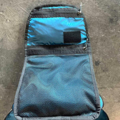 GORUCK backpack open lid showing blue interior and mesh gear pocket on concrete floor