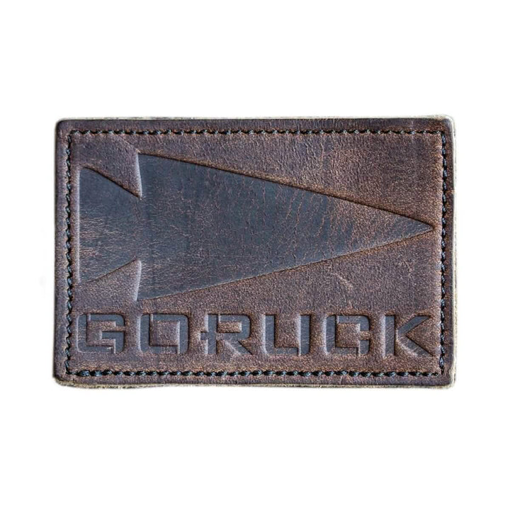 The Patch - Leather GORUCK Spearhead, by vendor-unknown, is made from full grain cowhide leather and showcases the GORUCK logo embossed along with a stylized arrowhead design.