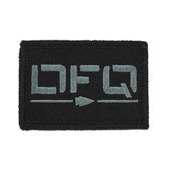 The "Patch - DFQ" by vendor-unknown is a rectangular, black embroidered patch showcasing the letters DFQ in gray-green. It features a small arrow pointing to the right beneath the letters and is carefully stitched along the edges with black thread. It includes a convenient VELCRO backing for easy attachment.