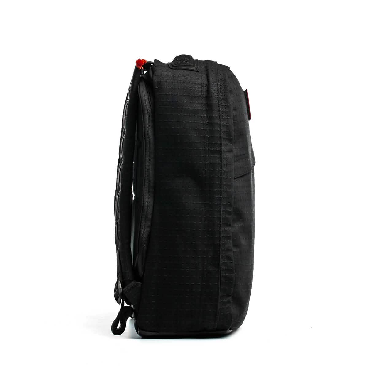 Side view of the GR1 USA x Carryology - GRXC2 Samurai black backpack, made from Japanese cotton fabric with a textured grid pattern, against a white background.