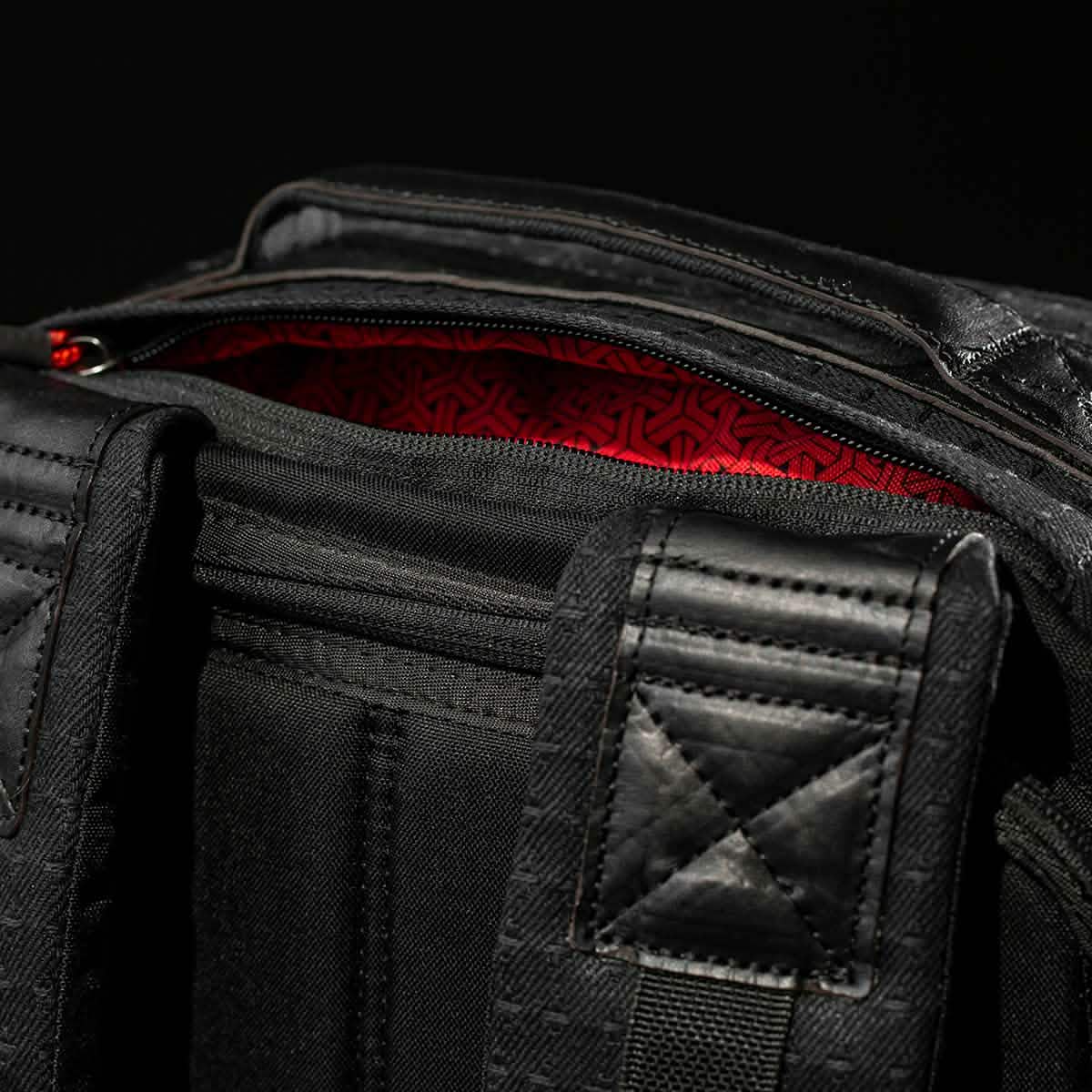 Close-up of the GR1 USA x Carryology - GRXC2 Samurai backpack, featuring padded straps and a red Japanese cotton fabric inner lining.