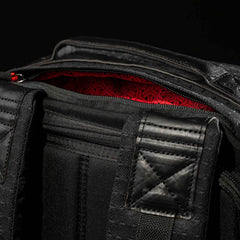 Close-up of the GR1 USA x Carryology - GRXC2 Samurai backpack, featuring padded straps and a red Japanese cotton fabric inner lining.