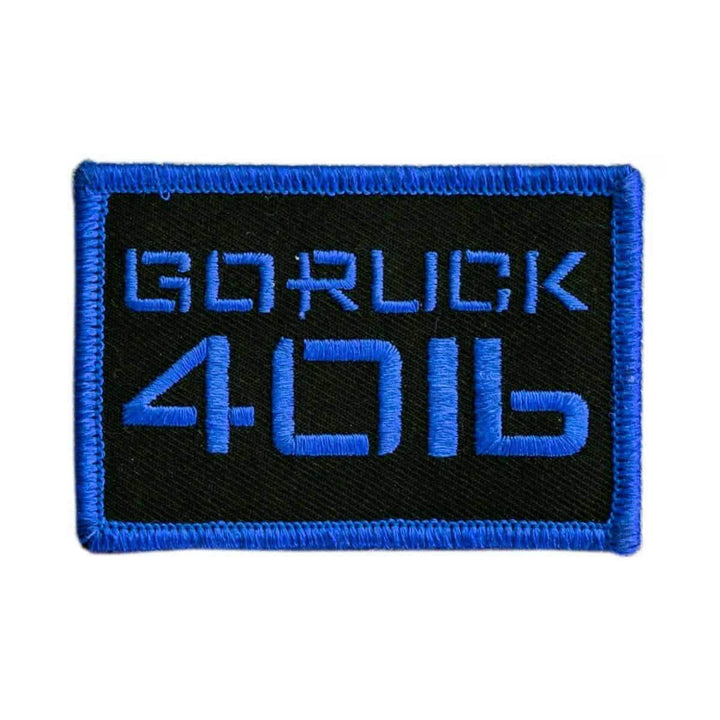 A black rectangular patch with a blue border, featuring bold and futuristic blue text displaying "GORUCK 4016." This patch, known as the Patch - Sandbag Weight by vendor-unknown, is crafted for those who value durability. It easily attaches to rucksacks using VELCRO.