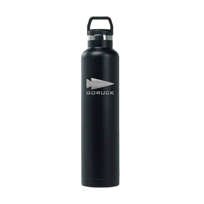 Introducing the GORUCK x RTIC Water Bottle, a tall and stylish black stainless steel bottle that showcases the GORUCK logo with an arrowhead design. This double wall insulated bottle features a secure cap with a handle for convenient carrying, offering quality comparable to RTIC bottles.