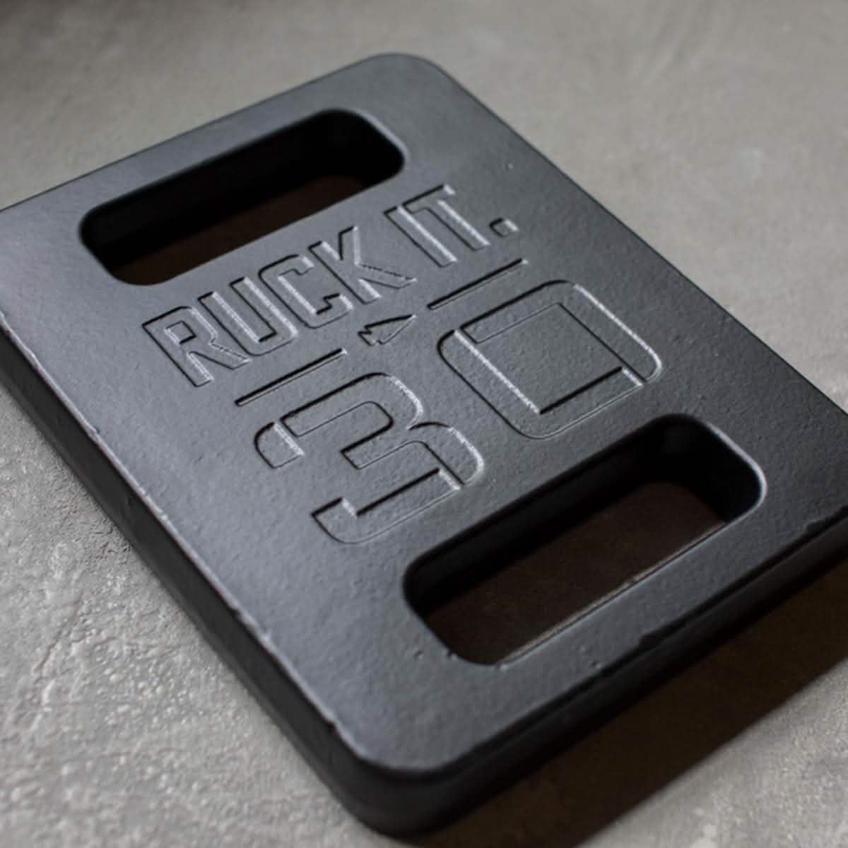 A rectangular black GORUCK Ruck Plate features two handle openings with the words 
