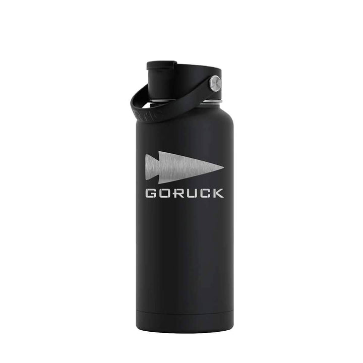 The GORUCK x RTIC water bottle by GORUCK features a sleek black stainless steel design with a silver logo and the word "GORUCK" engraved on its surface. It boasts a double-wall insulated construction to maintain beverage temperature, and comes equipped with a screw-on lid and handle for easy portability.