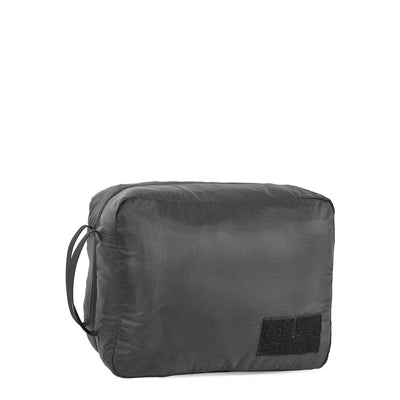 The GORUCK Packing Cube, made from black 200D nylon, features a side handle and a small sewn patch. This fully zipped, rectangular cube is perfect for organizing clothing or accessories in your travel ruck.